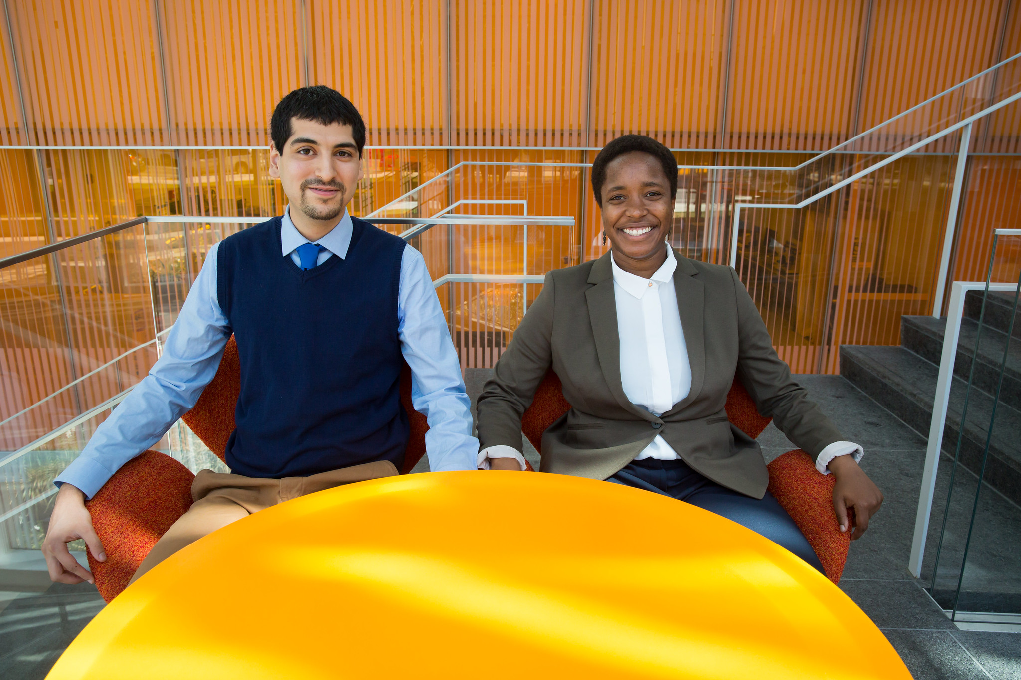 Man and woman sitting behind a yellow table