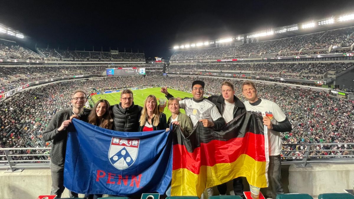 Penn postdocs hold up flags at a professional soccer game in Philadelphia
